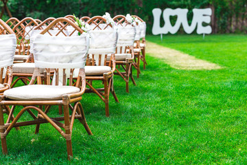 Wedding chairs decorated with flowers. Close up.
