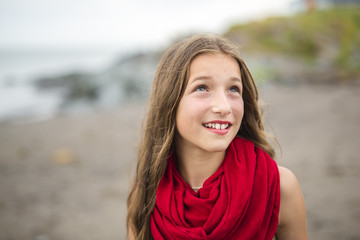 Girl enjoying the rain and having fun outside on the beach  a gray rainy