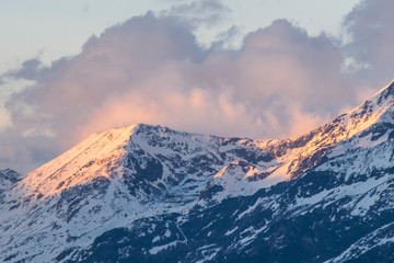 Golden sunrise on the snow mountain peak with the clouds