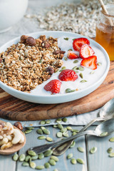 Homemade granola with fresh strawberry over vanilla yogurt. Healthy breakfast
