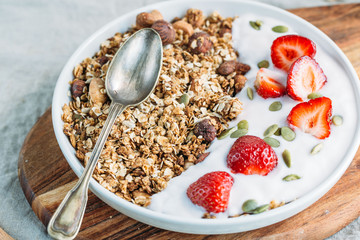 Homemade granola with fresh strawberry over vanilla yogurt. Healthy breakfast