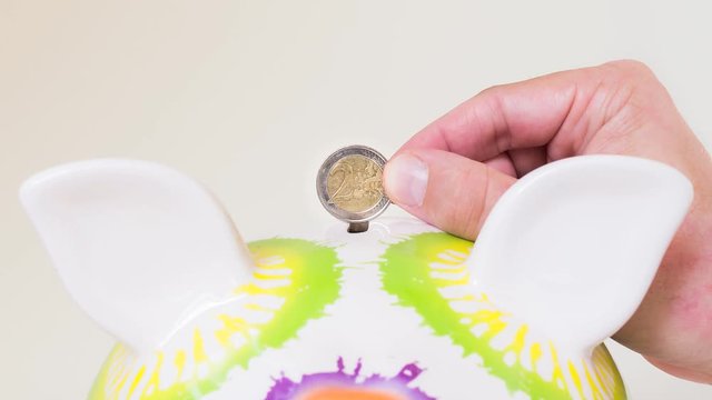 Photo sequence of euro coins and euro notes put in a piggy bank, low amount growing to high amount.