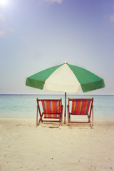 beach chairs with umbrella om the sand