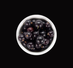 black currant in a bowl. Top view. Ripe and tasty currant isolat