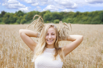 Fototapeta na wymiar Young woman in golden wheat field