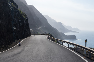 Road along a cliff with a mountain range
