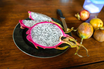 Dragon fruit cut open and served on a black plate
