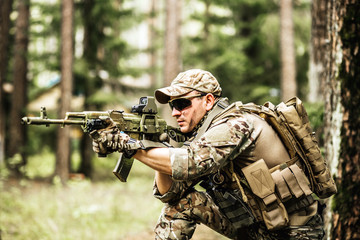 military. Armed man in a zone of armed conflict soldier in uniform targeting with assault rifle...