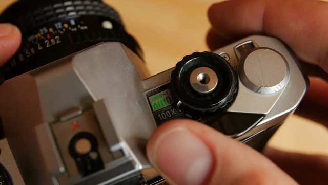 Old mechanical camera in hands. Close-up, top view.