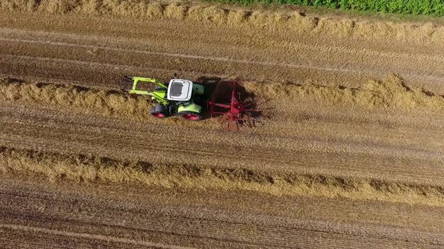Ernte - Landwirt wendet Stroh zum Trocknen, Luftaufnahme