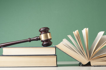 Law concept - Book with wooden judges gavel on table in a courtroom or enforcement office.