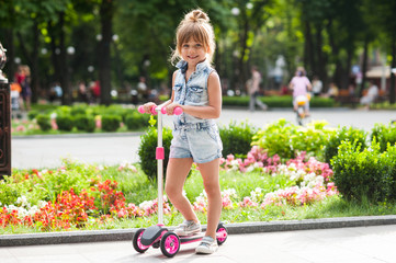 
little girl riding a scooter