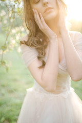 Naklejka premium Young beautiful bride portrait in park with flowers