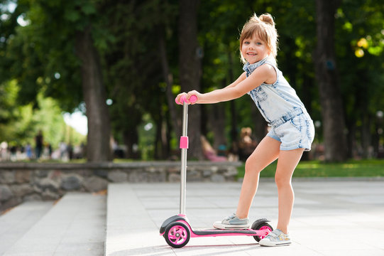 Little Girl Riding A Scooter