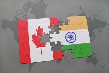 puzzle with the national flag of canada and india on a world map background.