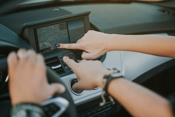 fingers pointing to the car gps system 