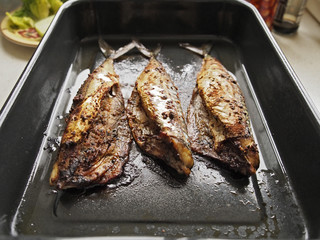 Cooked mackerel on a tray.