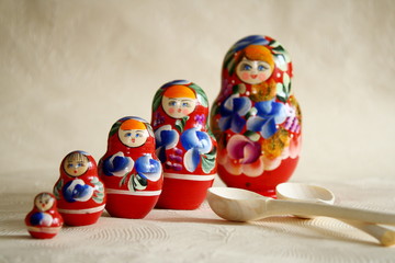 Row Russian Matryoshkas and two wooden spoons
