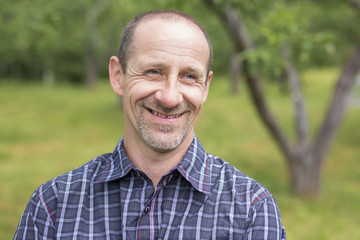 Fototapeta premium men outdoors smiling close to a tree in the forest