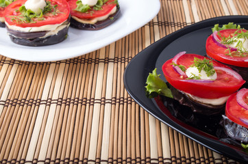 Plates with vegetarian salad stewed eggplant and fresh tomatoes