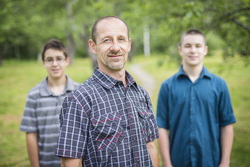 Portrait of happy father and teenager boy outdoor.