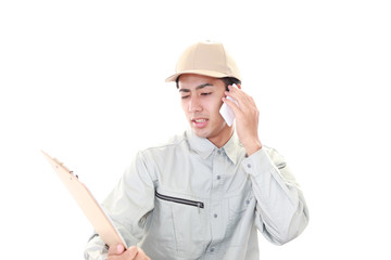 スマートフォンで通話中の労働者