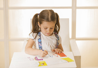 Little child writing letter A. Learning to write. Little girl writing alphabet in a copy book at a...
