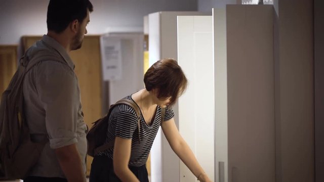 Beautiful young couple choosing a wardrobe in shop