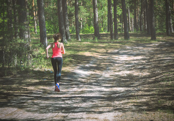 Young fitness woman running on forest trail. Runner athlete jogg
