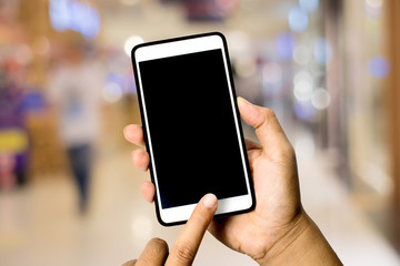 Hand hole smart phone on abstract blurred bookeh background