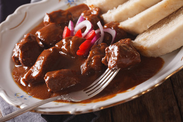 hot Czech goulash with knedliks in a plate close-up. horizontal
