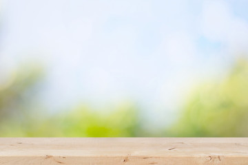 Fototapeta premium Wooden table with natural green and blue sky background.