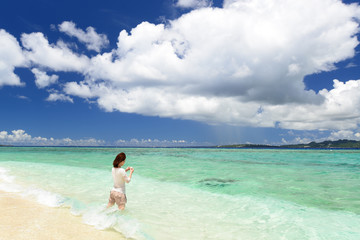 海辺で遊ぶ笑顔の女性