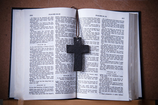 Wood cross necklace put on center of Christian Bible. Christianity photograph object.