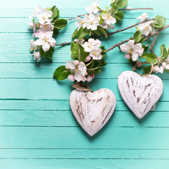 Two decorative heart and apple tree flowers on turquoise  wooden