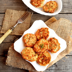 Fried fish cakes on a plate and on old wooden background. Cutlets cooked from salmon meat. Delicious and nutritious lunch or dinner recipe