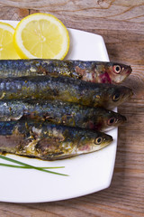 fish dish, grilled sardines with lemon on wooden background