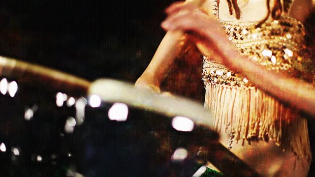female percussion drummer performing with bongos