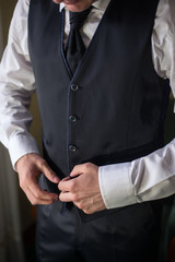 Man wearing a suit holding his jacket and standing