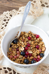 Homemade delicious healthy granola with nuts, seeds, honey and fresh berries in a ceramic cup 