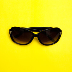 Stylish sunglasses on yellow background. fashion top view flat lay