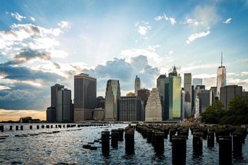 Panorama of Lower Manhattan and some pylons that stick out of the water on a cloudy day, in New York, USA