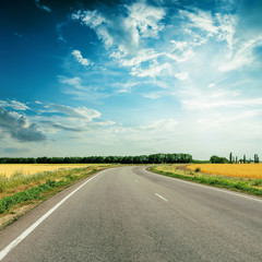 Fototapeta premium asphalt road to horizon under dramatic sky