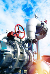 Industrial zone, Steel pipelines and valves against blue sky
