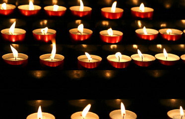 many candles lit inside the place of worship to pray