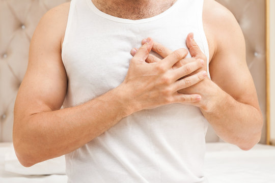 Young man with heart pain gesture