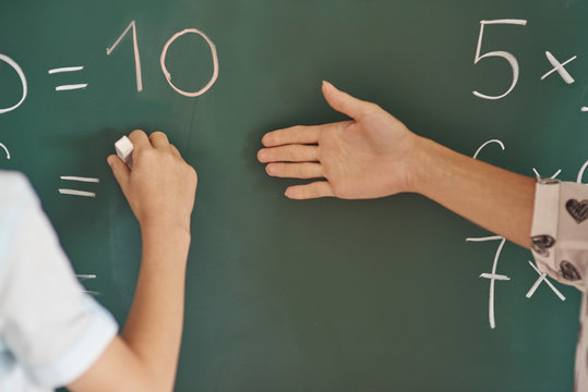 Teacher and her pupil next to the blackboard