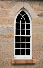 Fototapeta na wymiar Arched church window set in sandstone bricks