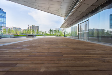 Empty wooden footpath front modern building