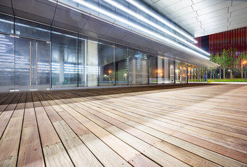 Empty wooden footpath front modern building